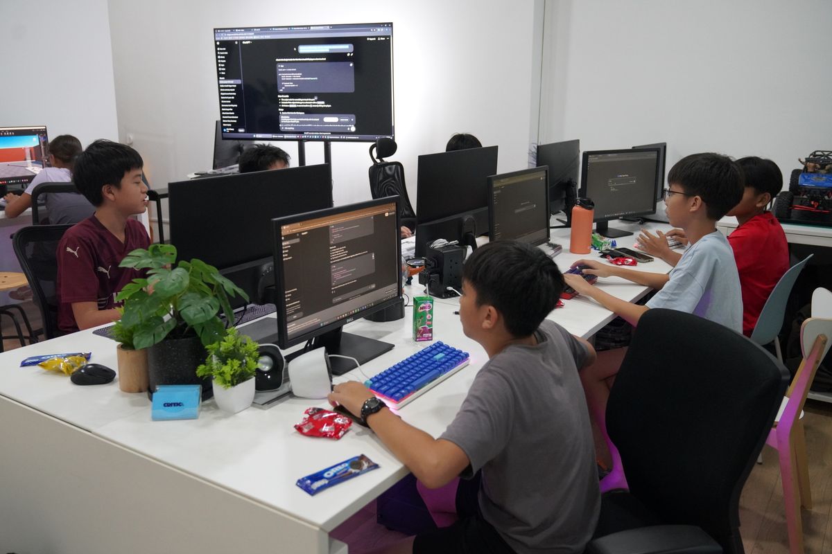 Students working on AI and vibe coding projects at their computers during the Mind Theory AI Sprint holiday camp