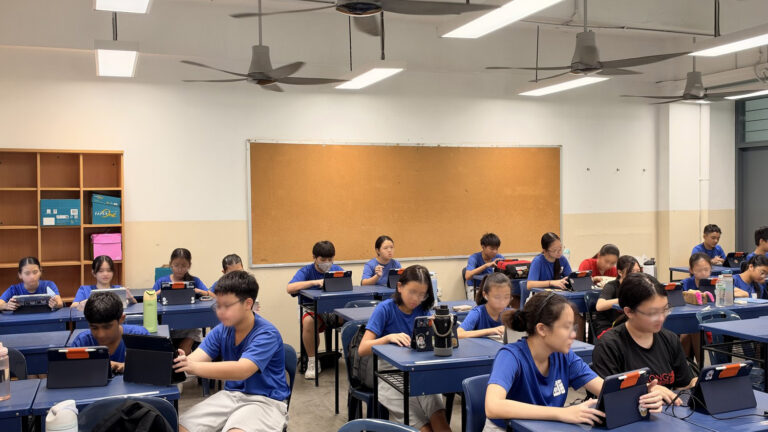 Classroom of Sec 1 students vibe coding on tablets