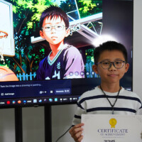 Boy holds certificate, stands before screen displaying his digital artwork