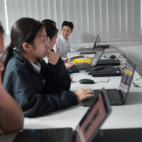 Students work on laptops in a classroom setting