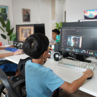 Young people work on video editing at computers in a bright office