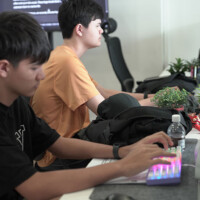 Two young men focused on computer work in a modern office setting