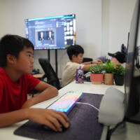 Young boy focused on computer screen in a tech workspace