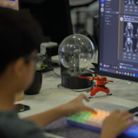Person works at desk with computer, keyboard, and decorative items