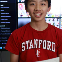 Smiling student in Stanford shirt holds achievement certificate
