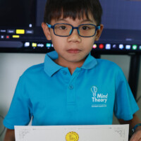 Young boy in blue shirt holds certificate of achievement