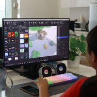 Child uses computer to design 3D game level with colorful interface